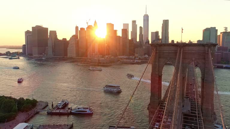 The aerial scenic view to Manhattan Downtown and Brooklyn Bridge from Brooklyn Heights over the East River at the sunset.