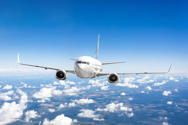 istock Airplane flies over the summer clouds and the earth's surface under the blue sky. 1020635430