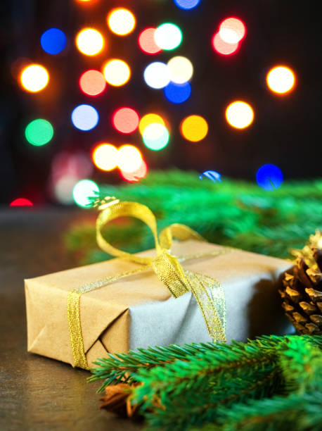 istock Christmas dark black background, gift and fir branches, magic shining bokeh, empty space for text 1020638484