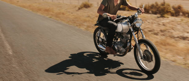 istock Man riding motorcycle on rural road 1020638930
