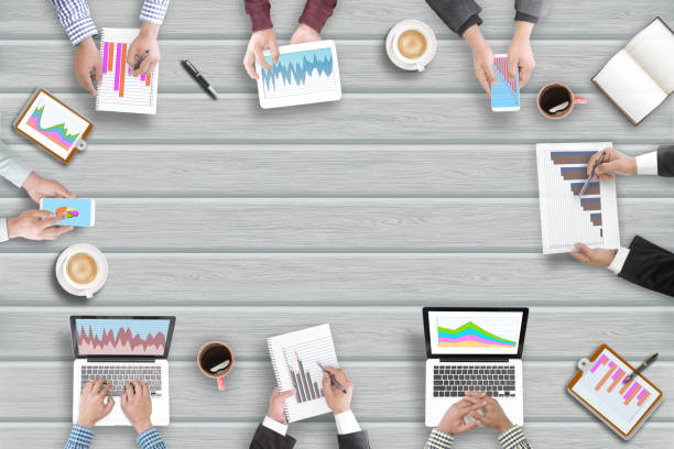 Top view of business people on meeting with their devices with data chart