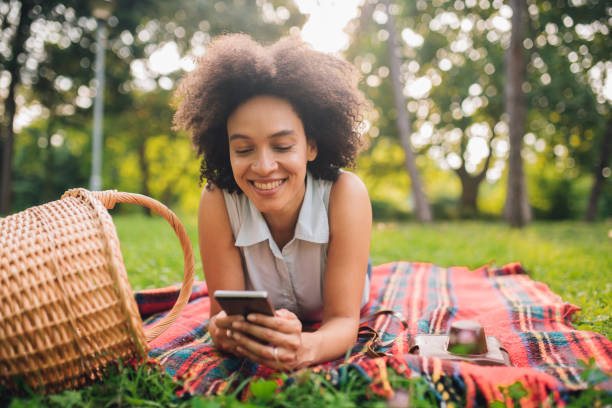istock Smiling woman text messaging on a picnic 1020675218