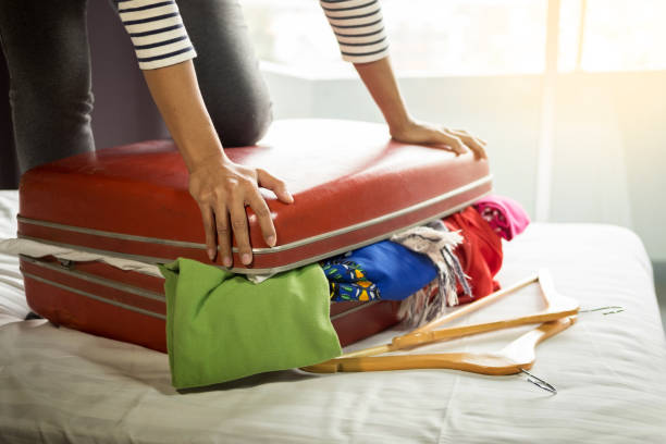 istock Midsection Of Woman Closing Suitcase On Bed 1020682258