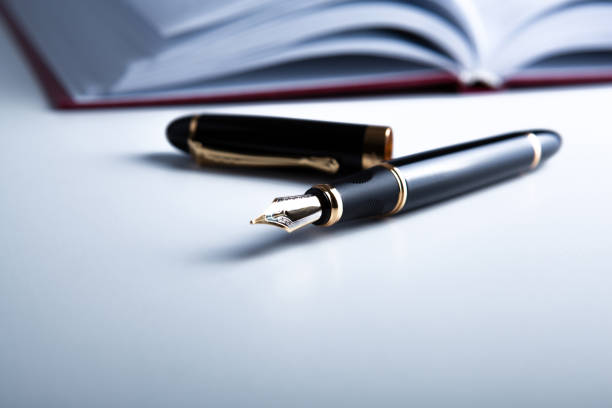 fountain pen with a diary on the desktop close up fountain pen with a diary on the desktop close up fountain pen photos stock pictures, royalty-free photos & images