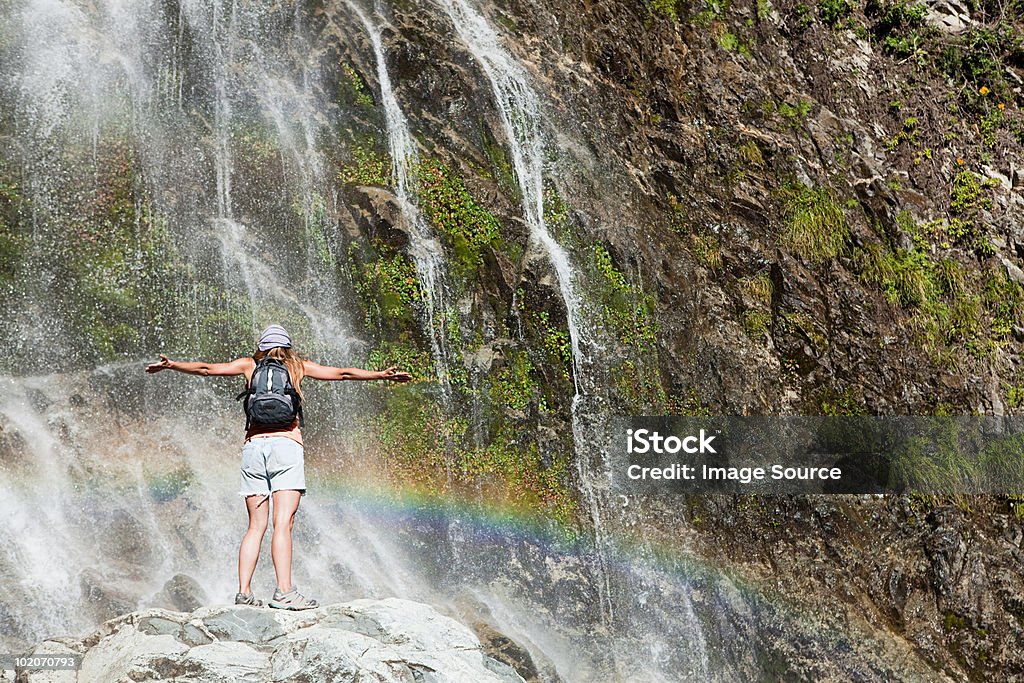 Donna in piedi con le braccia aperte in cascata - Foto stock royalty-free di Bariloche