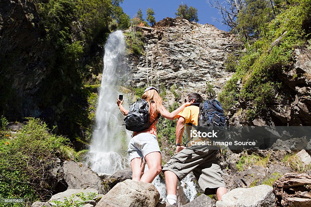 Coppia prendendo foto di cascata - Foto stock royalty-free di 30-34 anni