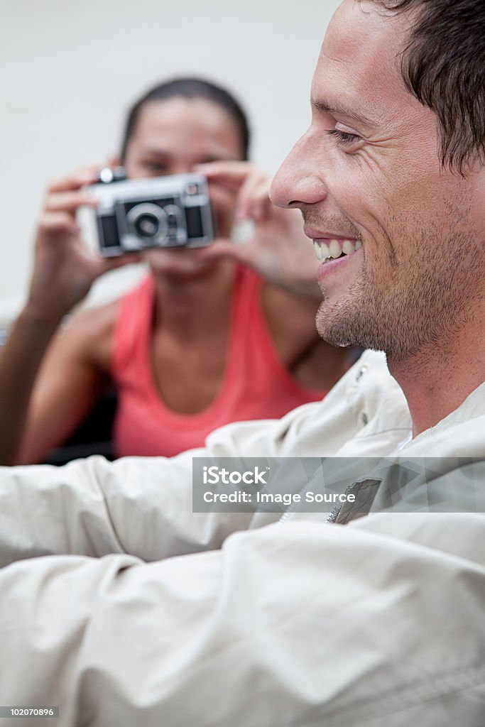 Młoda kobieta biorąc zdjęcie mężczyzny w Kabriolet samochodem - Zbiór zdjęć royalty-free (30-34 lata)