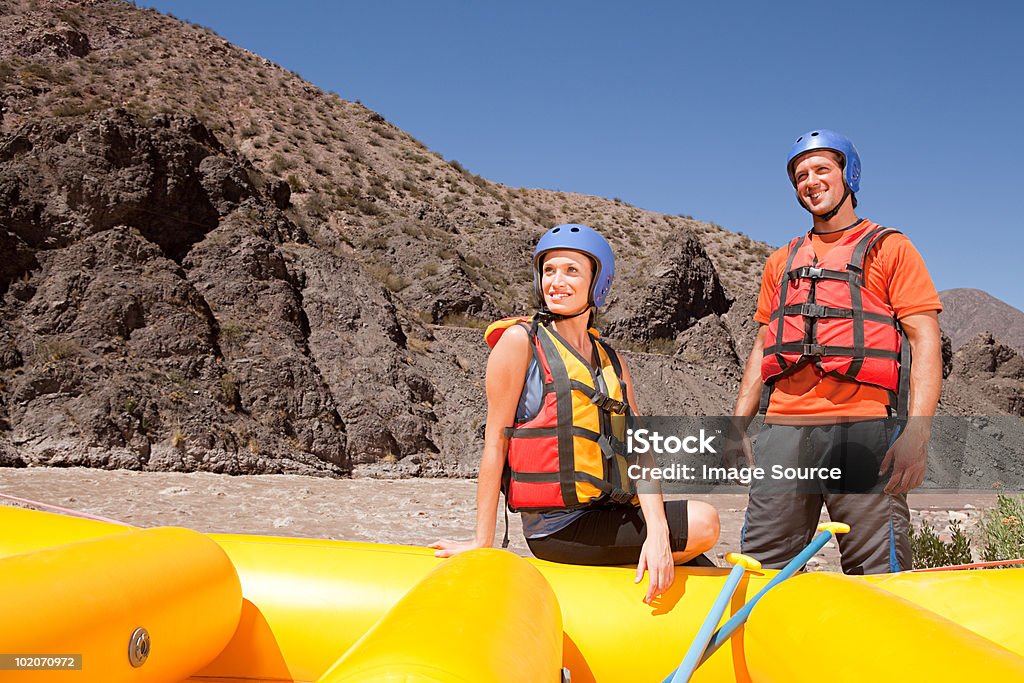 Hombre y mujer listo para practicar rafting en aguas rápidas - Foto de stock de 20-24 años libre de derechos