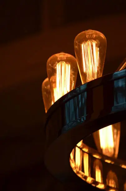 The warm dim glow of Edison bulbs in a bronze chandelier