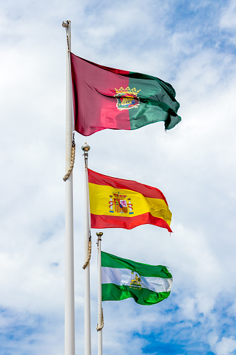 Spanish and Andalucian flags flying in a breeze