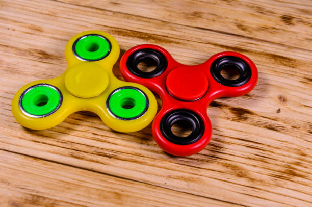 istock Two fidget spinners on wooden desk 1020763876