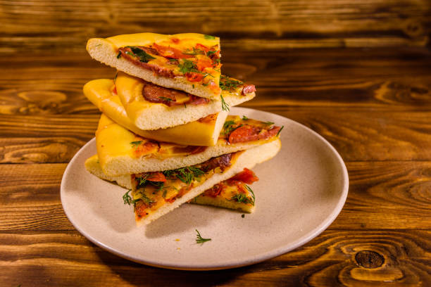 ceramic plate with sliced homemade pizza on a wooden table - pepperoni pizza green olive italian cuisine tomato sauce imagens e fotografias de stock