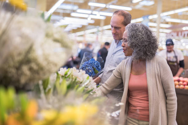 그의 아내와 식료품가 게에서 꽃으로 수석 남성 따기 - florist supermarket flower bouquet 뉴스 사진 이미지