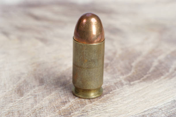 istock The .45 caliber cartridge on wooden background 1020774924