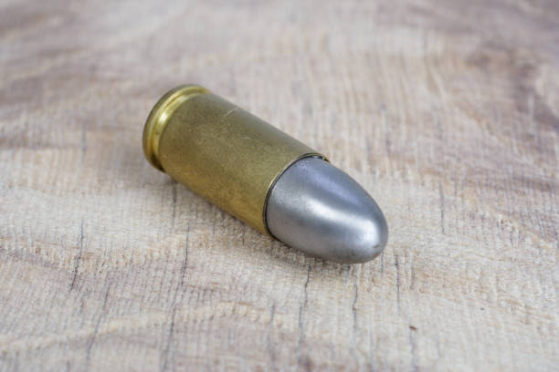 The 9mm caliber cartridge on wooden background