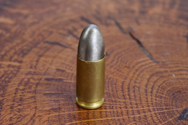 The 9mm caliber cartridge on wooden background