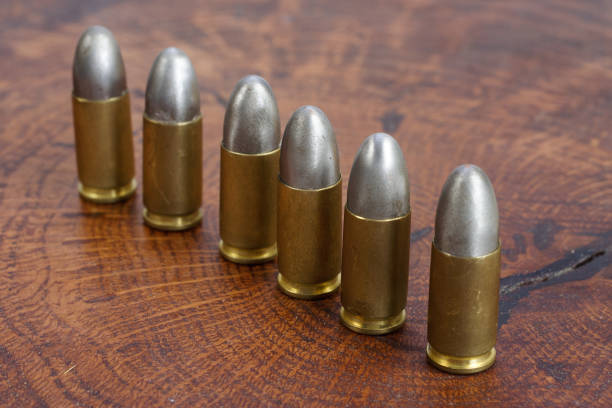 The 9mm caliber cartridge on wooden background