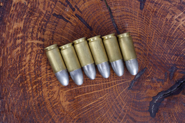 The 9mm caliber cartridge on wooden background