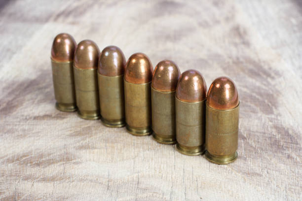 The .45 caliber cartridge on wooden background