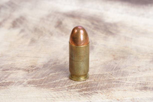 istock The .45 caliber cartridge on wooden background 1020774992