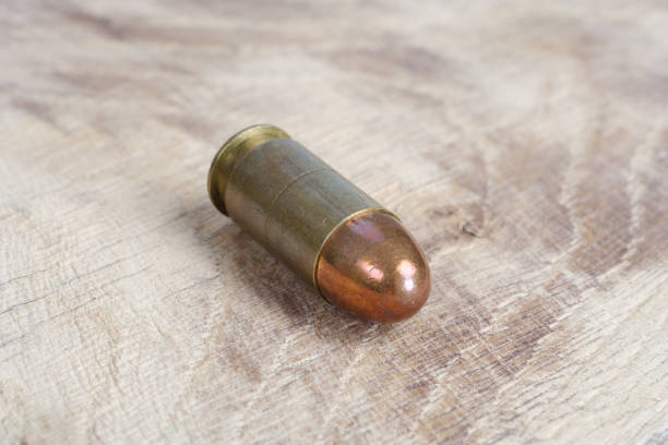 istock The .45 caliber cartridge on wooden background 1020775044