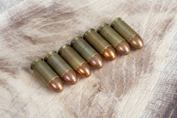 The .45 caliber cartridge on wooden background