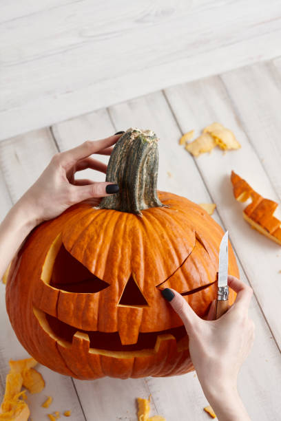 istock Carving halloween pumpkin into jack-o-lantern, close up view 1020788696