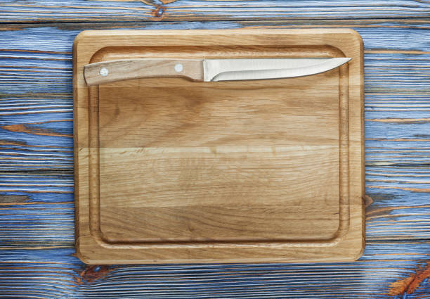 Chopping board knife on vintage wooden background.