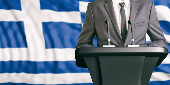 Businessman or politician making speech on Greece flag background. 3d illustration