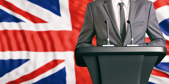 Businessman or politician making speech on Great Britain flag background. 3d illustration