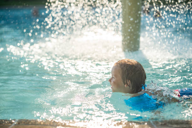 istock Profile view cute little boy swimming in the pool 1020803636