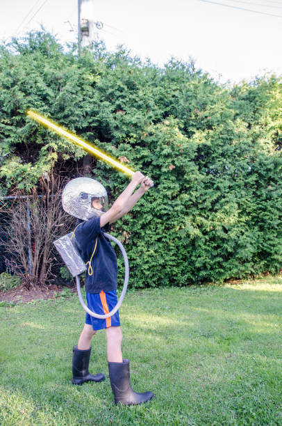 Young boy dressed as an astronaut in the backyard during summer day
