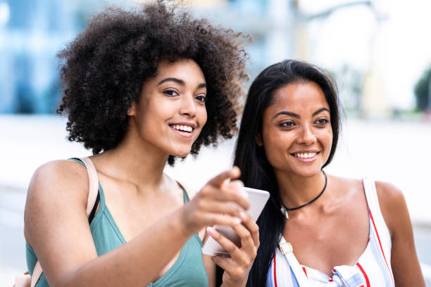 istock Women with smart phone walking on street 1020831994