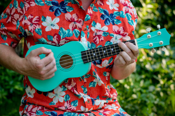 mann mit hawaii-hemd und ukulele - ukulele stock-fotos und bilder