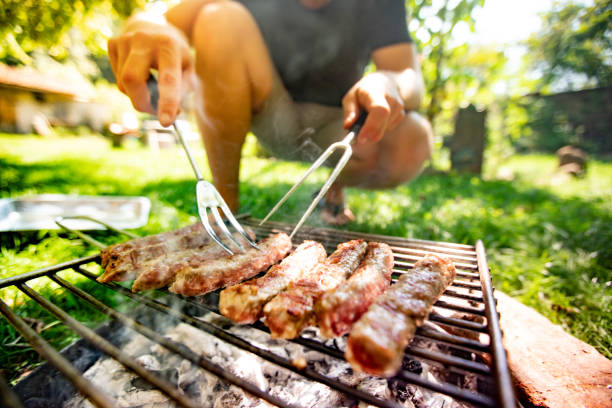 istock Young Man Grilling Meat on Barbecue 1020844252