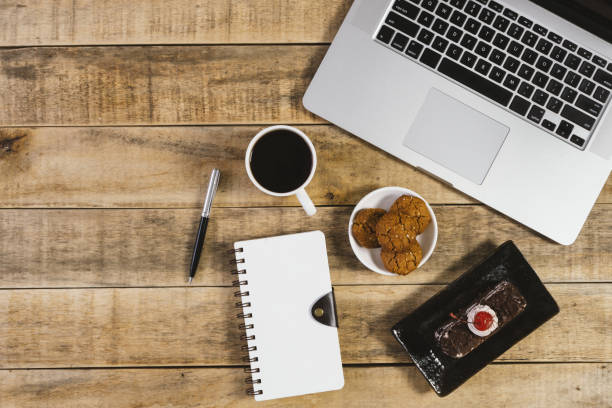 istock Laptop, diary and breakfast on wood background. 1020854350