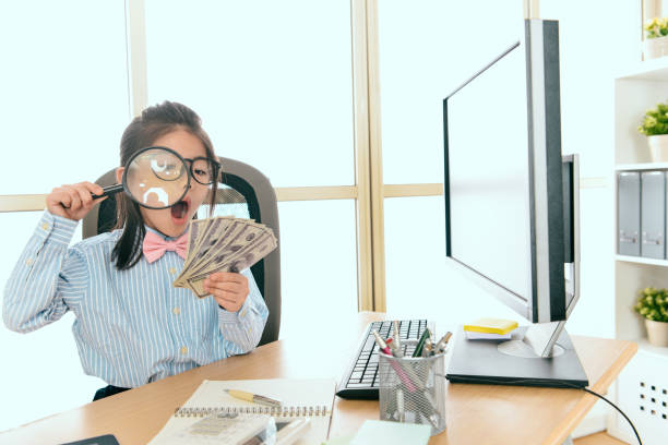 beauty young little female company manager beauty young little female company manager holding many banknote money sitting in office and using magnifier looking feeling shocked. photographic enlarger stock pictures, royalty-free photos & images