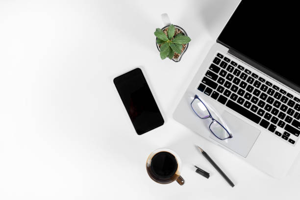 istock Office table with laptop computer, smartphone, pen, notebook and coffee on isolated pure white background / Laptop and tablet mockup concept. (Selective Focus) 1020950320