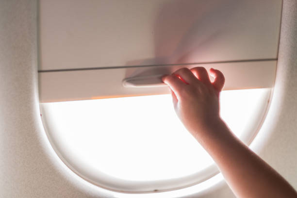 istock Close up childs hand adjusting blinds on airplane window 1020955358