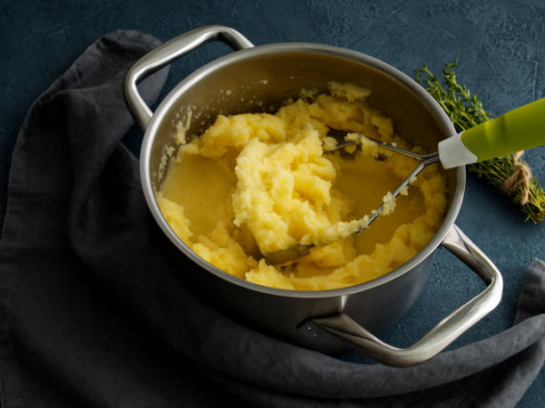 istock Mashed potatoes in bowl on dark stone blue table, rosemary, napkin, side view, close up 1020966718