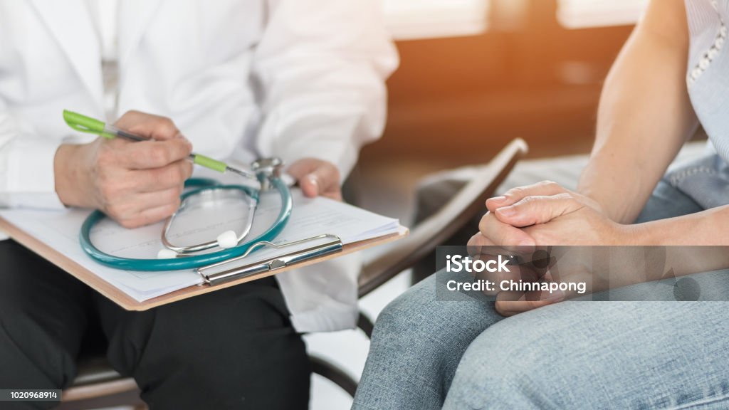 Doctor or psychiatrist consulting and diagnostic examining stressful woman patient on obstetric - gynecological female illness, or mental health in medical clinic or hospital healthcare service center Doctor Stock Photo