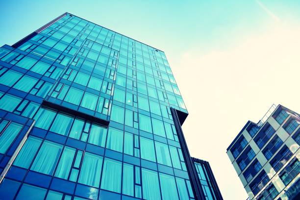 istock Modern office building on a clear sky background. Retro stylized colorful tonal filter effect 1020972572