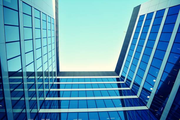 istock Modern office building on a clear sky background. Retro stylized colorful tonal filter effect 1020972882
