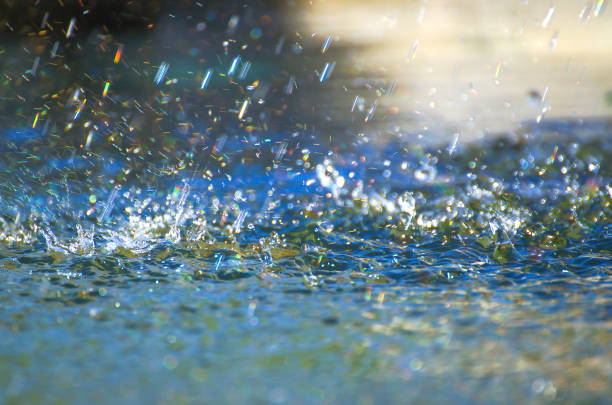 Drops of heavy rain on water Detail of rain drops in a storm on a road heavy rainfall stock pictures, royalty-free photos & images