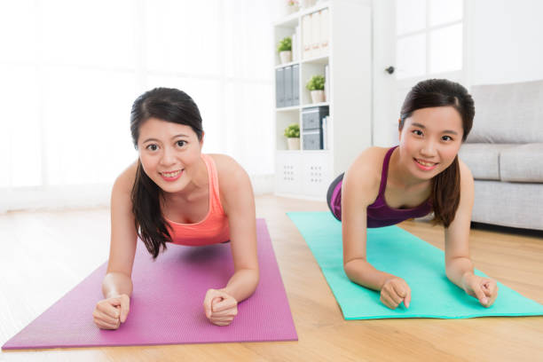 istock young pretty female friends making plank posture 1021001146