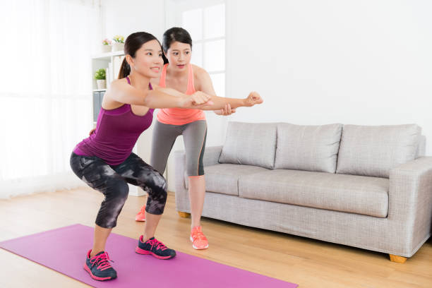 istock smiling girl training body and making squatting 1021003566
