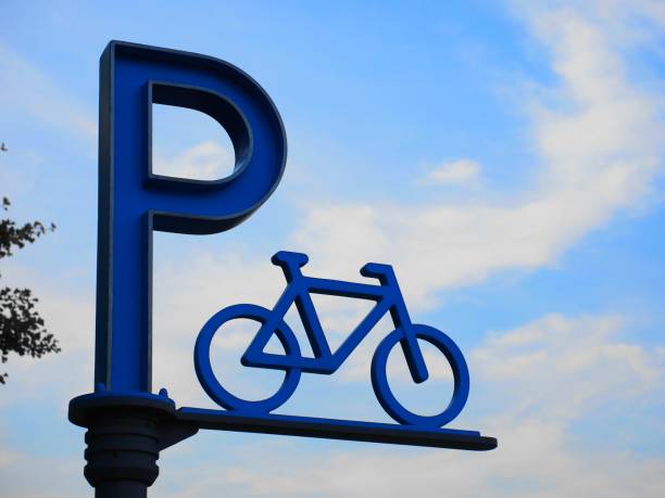 fahrrad-parken zeichen gegen blauen himmelshintergrund - parking lot parking sign sign letter p stock-fotos und bilder