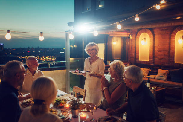 senior rooftop dinner party - dining senior adult friendship mature adult imagens e fotografias de stock