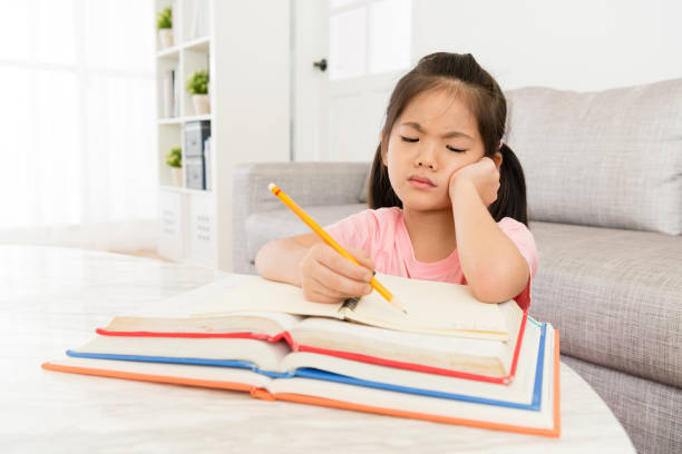 children little girl preparing back to school beautiful young children little girl preparing back to school study and must finish all learning homework feeling unhappy. japan small apartment stock pictures, royalty-free photos & images