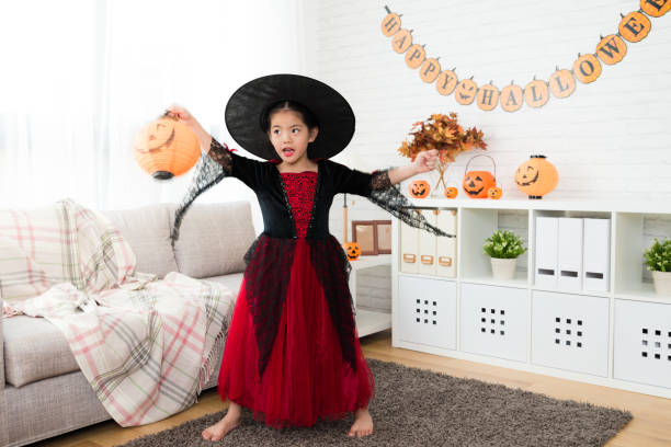 istock girl holding pumpkin lantern play alone 1021037872